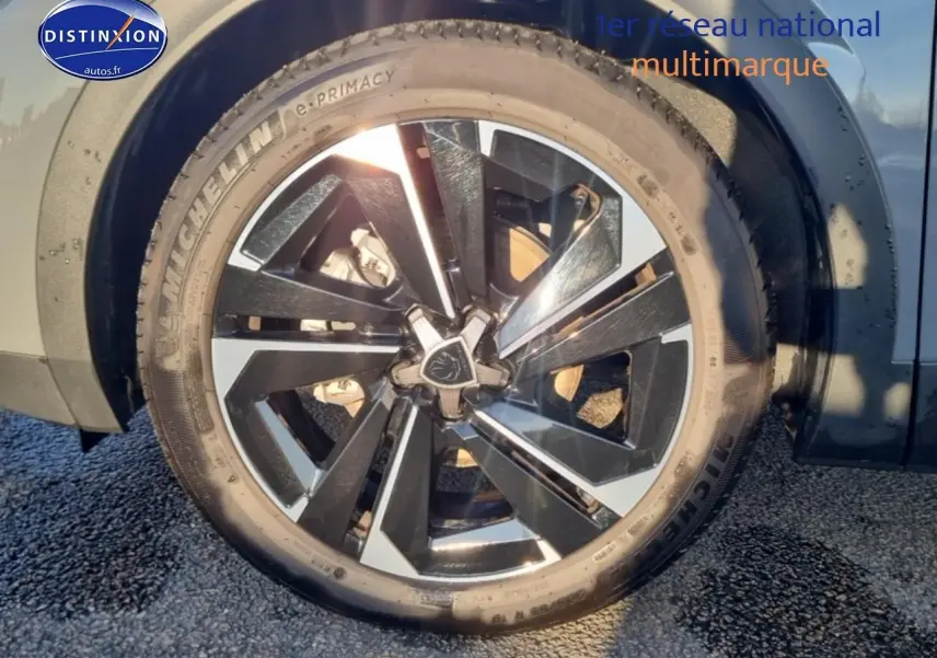 Gros plan sur la jante alu bicolore et le pneu Michelin d'une Peugeot 408 gris sélénite côté arrière droit.