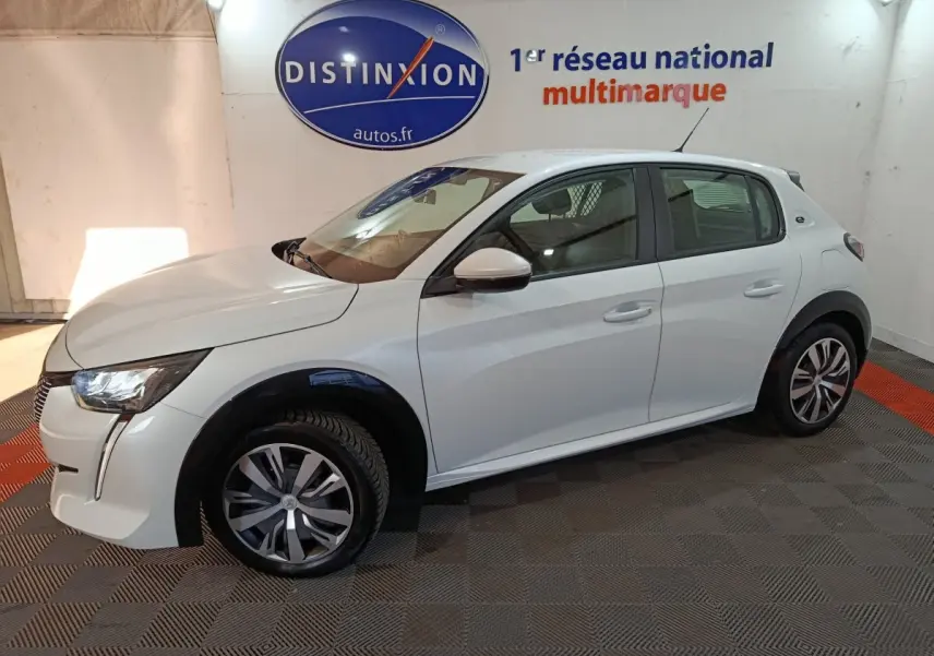 Peugeot 208 Electrique Active Business blanc vue de profil côté gauche en intérieur avec jantes stylisées.