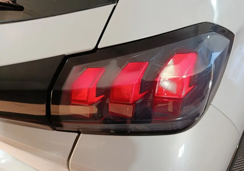 Gros plan sur le feu arrière droit rouge de la Peugeot 208 électrique Active Business blanche, vue arrière côté droit.