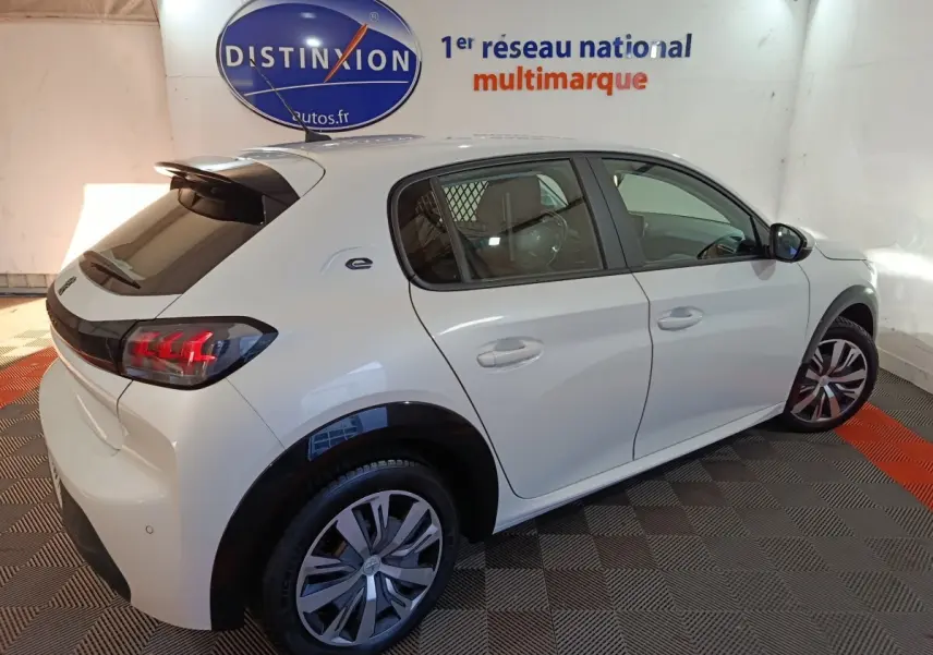 Vue 3/4 arrière droite d'une Peugeot 208 électrique Active Business blanche avec feux LED et jantes spécifiques.