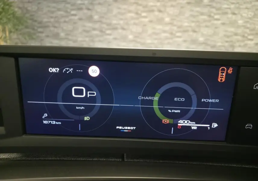 Affichage numérique du tableau de bord Peugeot 5008 hybride, avec indicateurs de vitesse, charge et autonomie à 400 km.