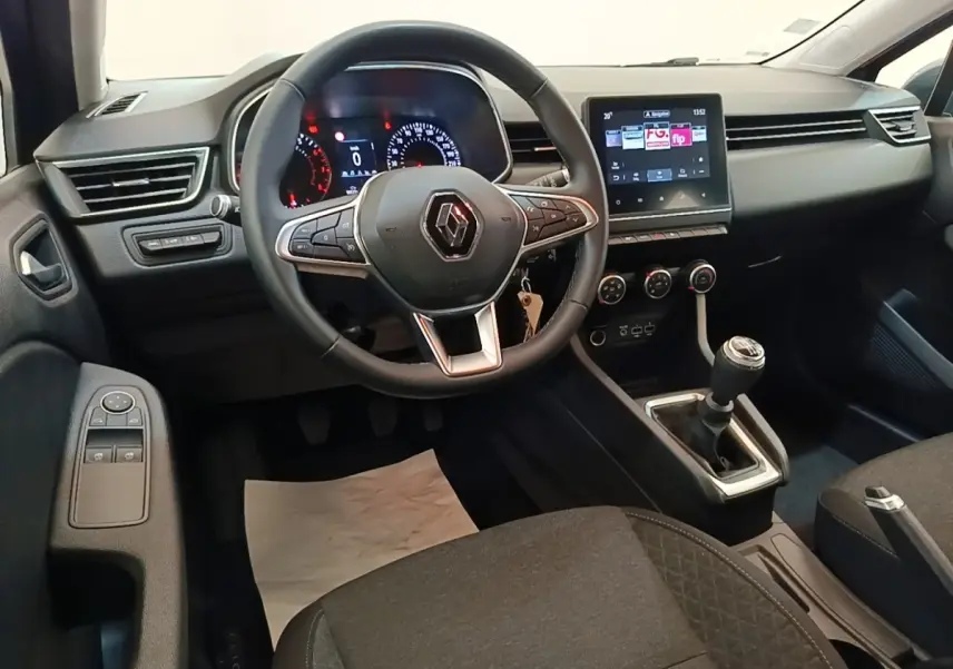 Vue intérieure avant de la Renault Clio Business TCe 100 2021, tableau de bord noir avec écran tactile et volant multifonctions.