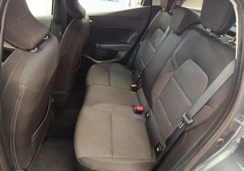 Vue côté gauche des sièges arrière gris foncé en tissu de la Renault Clio Business TCe 100, avec ceintures et appuie-têtes visibles.
