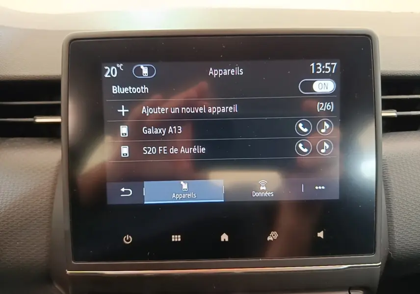 Écran tactile central affichant la connexion Bluetooth dans le tableau de bord d'une Renault Clio Business gris foncé.