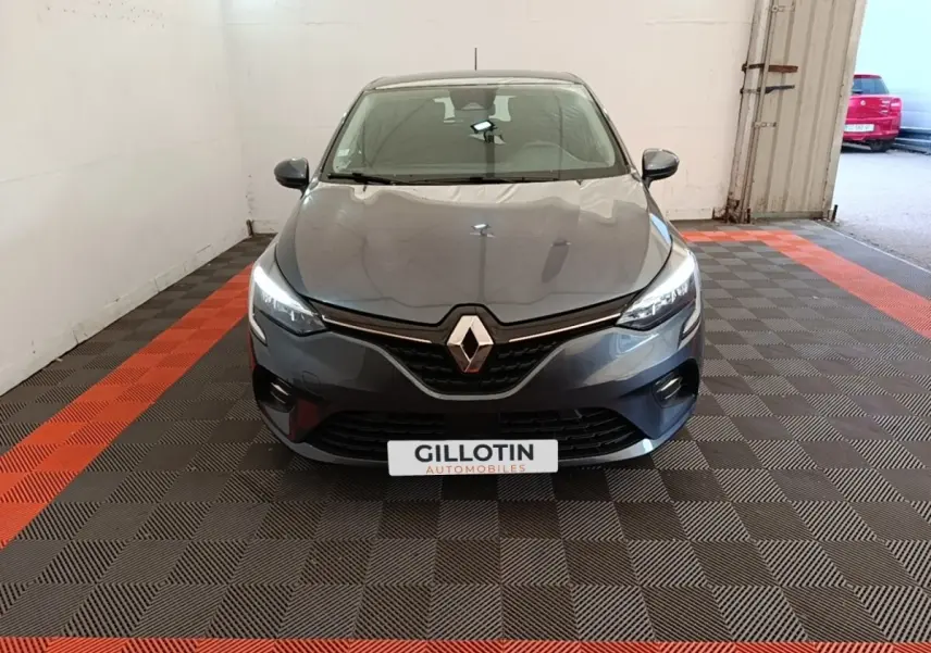 Renault Clio Business TCe 100 gris foncé vue de face, phares LED allumés dans un garage.