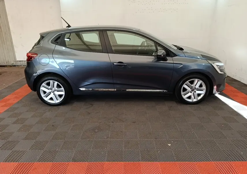 Profil droit d'une Renault Clio Business TCe 100 gris foncé, avec jantes alliage et poignées de porte intégrées.