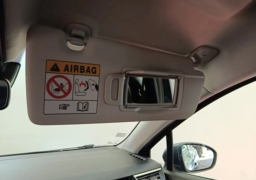 Vue intérieure côté droit sur le pare-soleil avec miroir et avertissement airbag dans une Renault Clio gris foncé 2021.