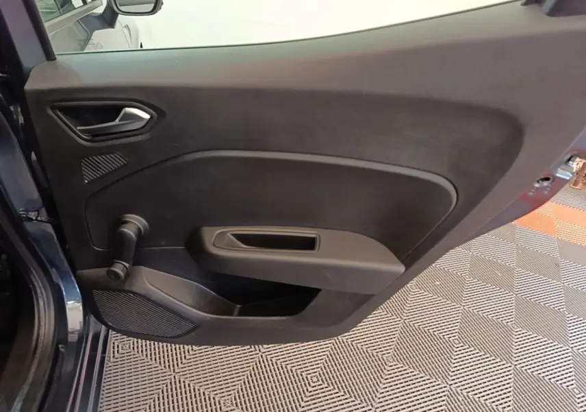 Vue rapprochée de la porte arrière gauche gris foncé de la Renault Clio Business TCe 100 avec manivelle de vitre manuelle.