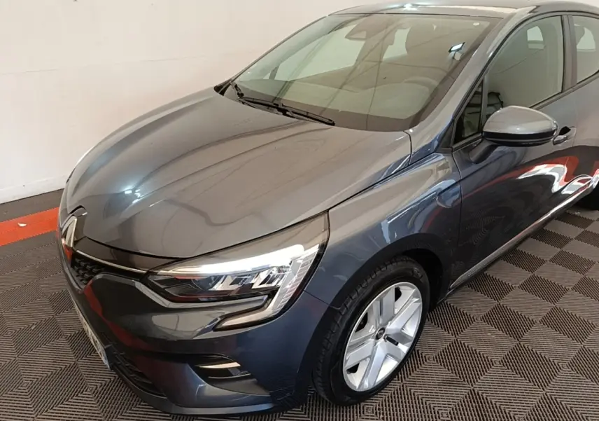 Renault Clio Business TCe 100 gris foncé vue 3/4 avant droit, avec phares LED et jantes alliage visibles.