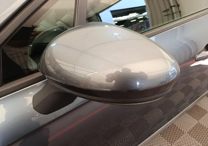 Rétroviseur côté gauche gris foncé de Renault Clio Business TCe 100 2021, avec reflet et partie de la portière visible.
