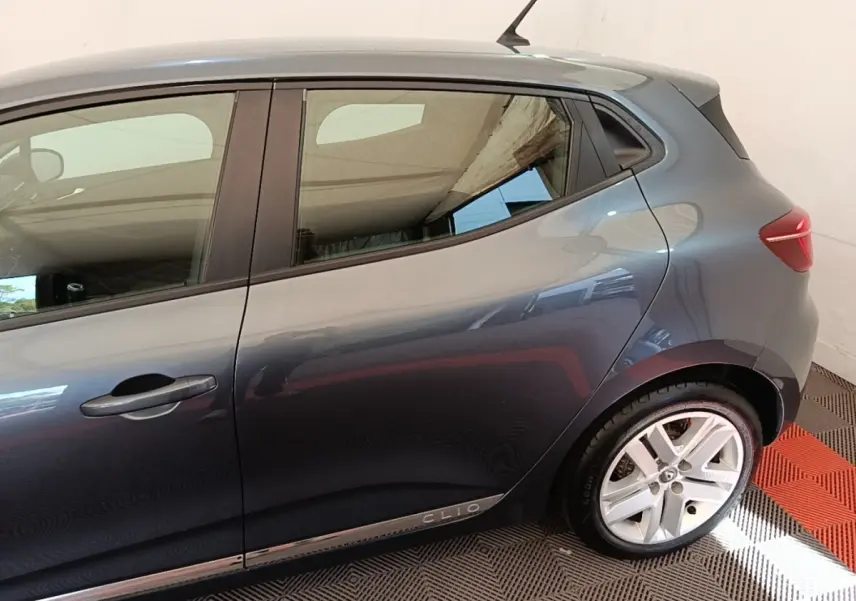 Vue latérale droite d'une Renault Clio Business TCe 100 gris foncé avec jantes alliage et poignées de porte intégrées.