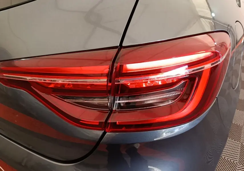 Gros plan sur le feu arrière droit rouge d’une Renault Clio Business TCe 100 gris foncé de 2021.