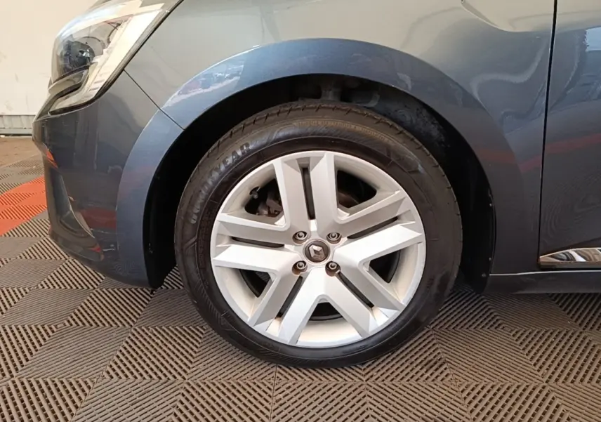 Gros plan sur la roue avant gauche d'une Renault Clio Business TCe 100 gris foncé avec jante alliage cinq branches.
