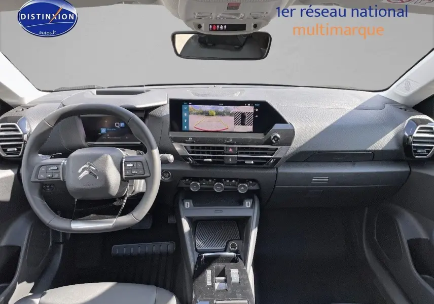 Intérieur de la Citroën C4 2024 gris platinium, vue frontale du tableau de bord avec écran tactile et volant multifonction.