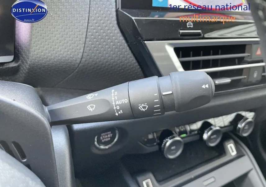 Gros plan sur la commande d'essuie-glace à gauche du volant dans l'habitacle d'une Citroën C4 gris platinium 2024.