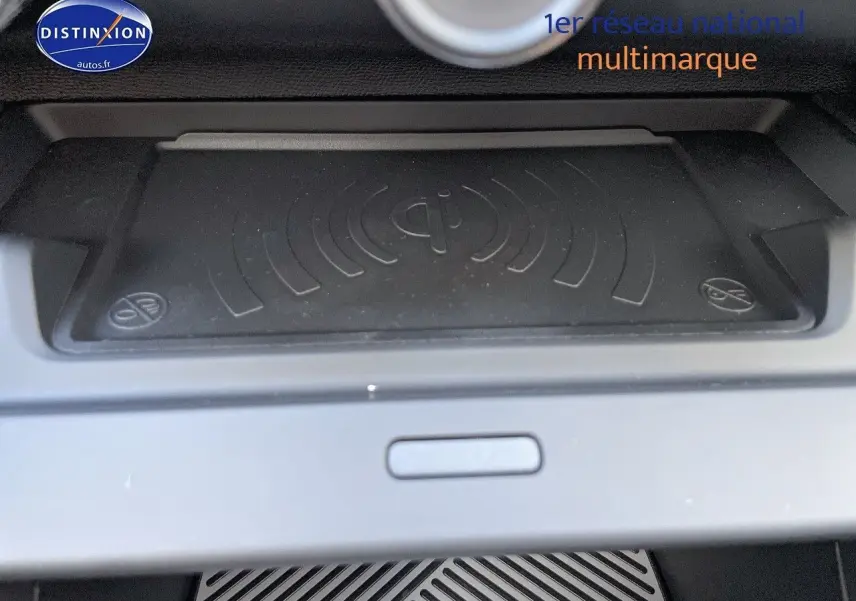 Surface de recharge sans fil Qi en gros plan dans l'habitacle d'une Citroën C4 gris platinium 2024.