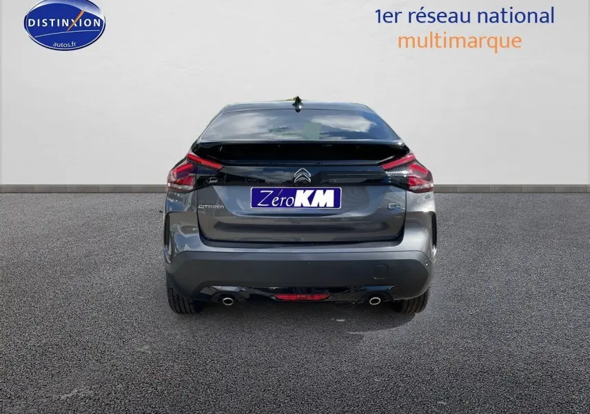 Vue arrière d'une Citroën C4 2024 gris platinium métal avec feux LED et double sortie d'échappement visible.