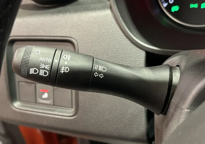 Gros plan sur la commande des phares et clignotants du Dacia Duster 2022, finition Journey, intérieur noir.