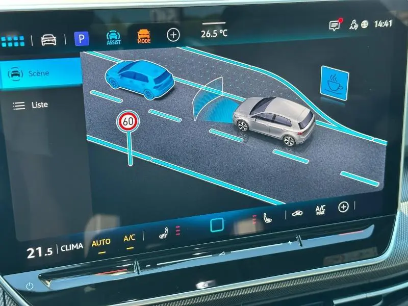 Écran tactile intérieur montrant l’aide à la conduite d’une Volkswagen Golf noire 2025 en vue 3/4 arrière droite.