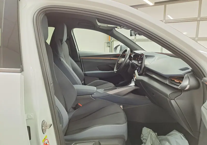 Vue intérieure côté conducteur du CUPRA TERRAMAR blanc Nevada 2025, sièges tissu noir et tableau de bord moderne.