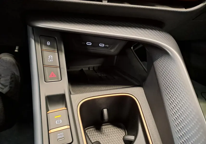 Vue rapprochée de la console centrale intérieure du CUPRA TERRAMAR 2025 avec finitions cuivrées et ports USB visibles.