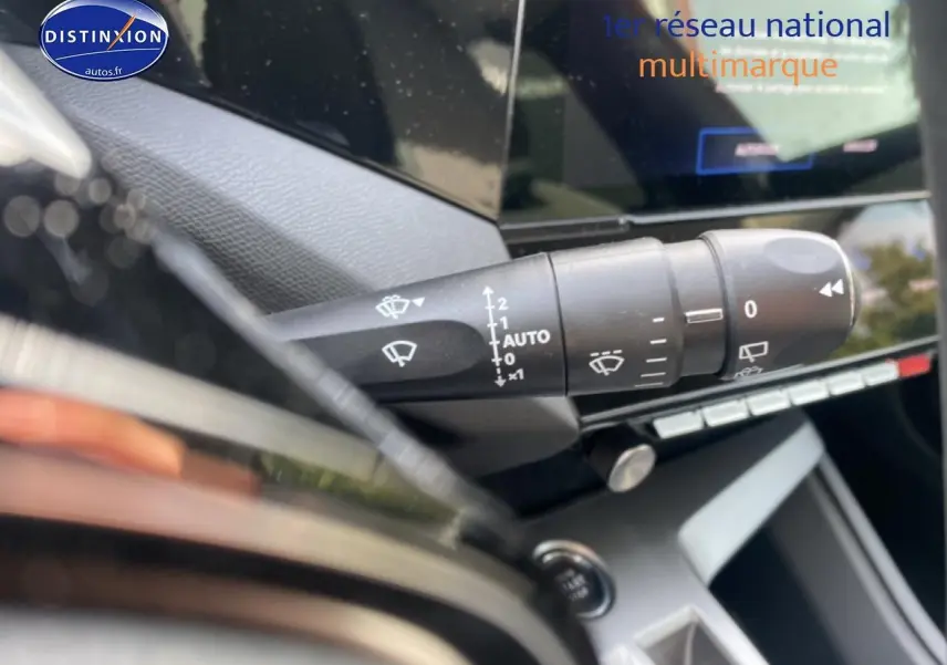 Gros plan sur la commande d’essuie-glace à gauche du volant dans l’habitacle du Peugeot 308 SW gris sélénite.