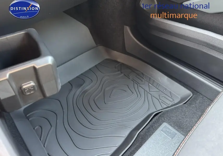 Détail de la moquette et du bac de rangement côté passager du Dacia Bigster gris schiste, intérieur sobre et fonctionnel.