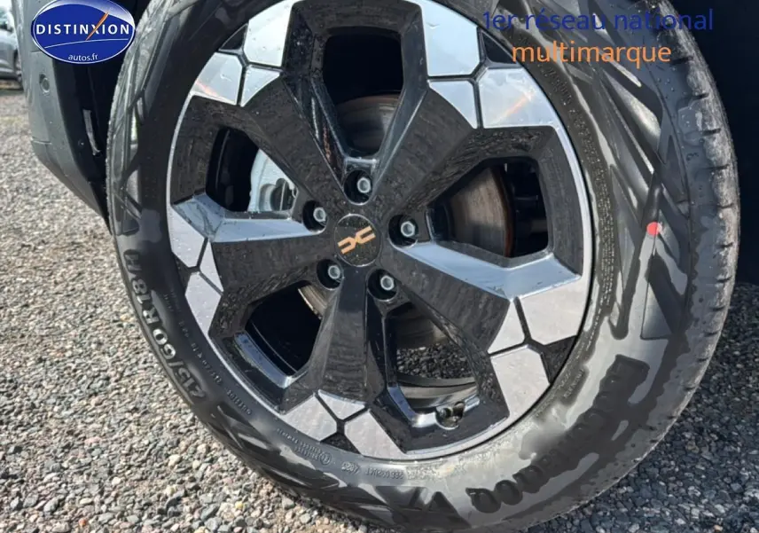 Gros plan sur la jante alu noire et argentée du côté avant droit du Dacia Bigster gris schiste.