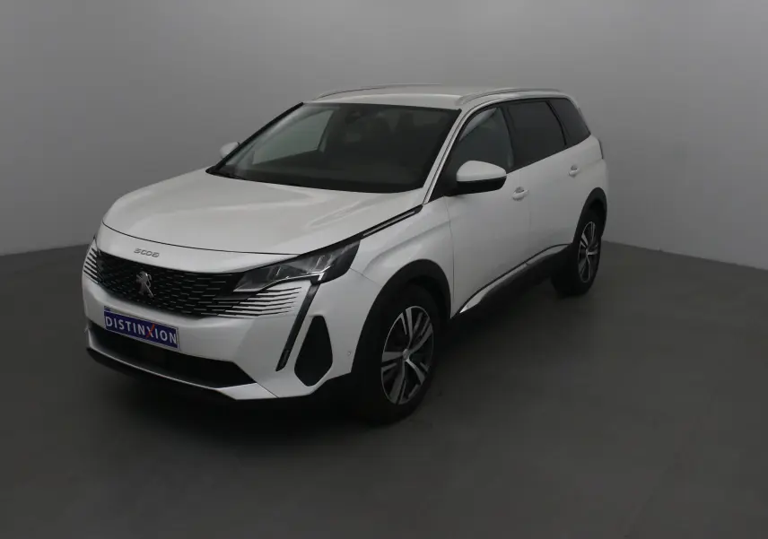 Peugeot 5008 blanc nacré en 3/4 avant droit, avec calandre distinctive et jantes alliage 18 pouces.