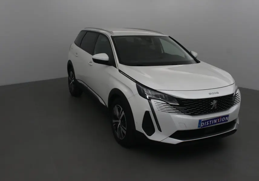 Peugeot 5008 blanc nacré en 3/4 avant droit, mettant en valeur sa calandre noire et ses optiques LED fines.