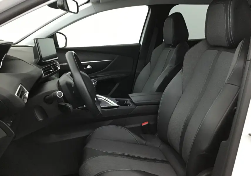 Vue intérieure côté conducteur du Peugeot 5008 2021, sièges en cuir noir avec surpiqûres blanches et tableau de bord moderne.