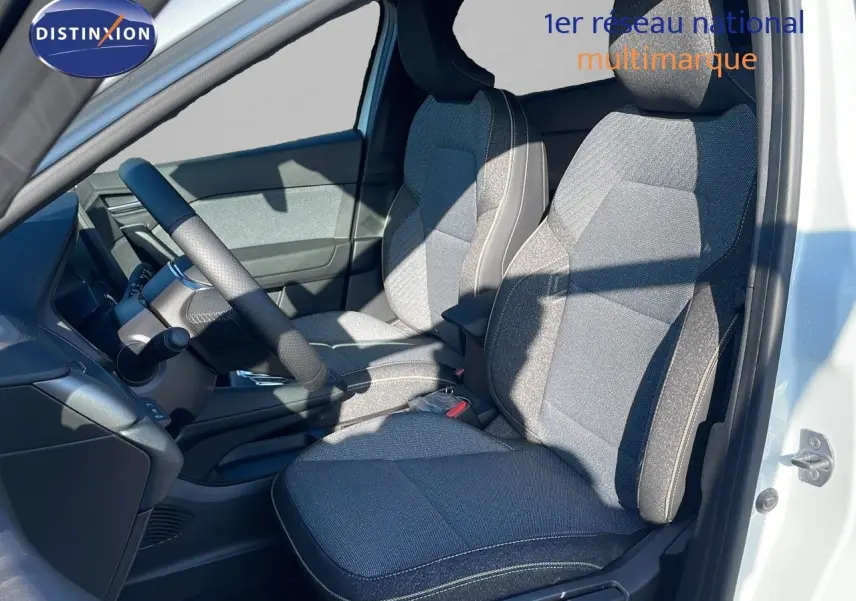 Vue intérieure côté conducteur du Renault Captur blanc nacré, sièges tissu gris avec surpiqûres claires.