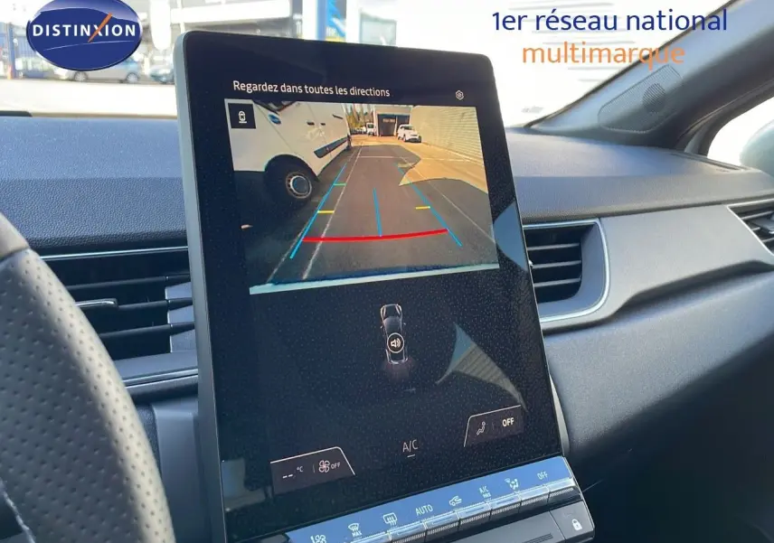 Vue intérieure du tableau de bord du Renault Captur blanc nacré, écran tactile affichant la caméra de recul en marche.