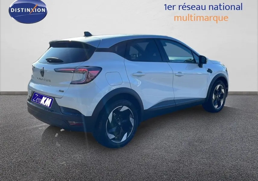 Renault Captur blanc nacré avec toit gris vu en 3/4 arrière droit, soulignant ses jantes noires et lignes modernes.