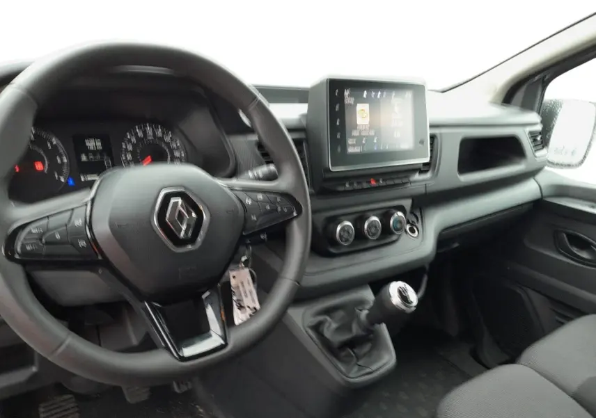 Intérieur du Renault Trafic Combi 2023, vue du poste de conduite avec volant multifonction et écran tactile central.