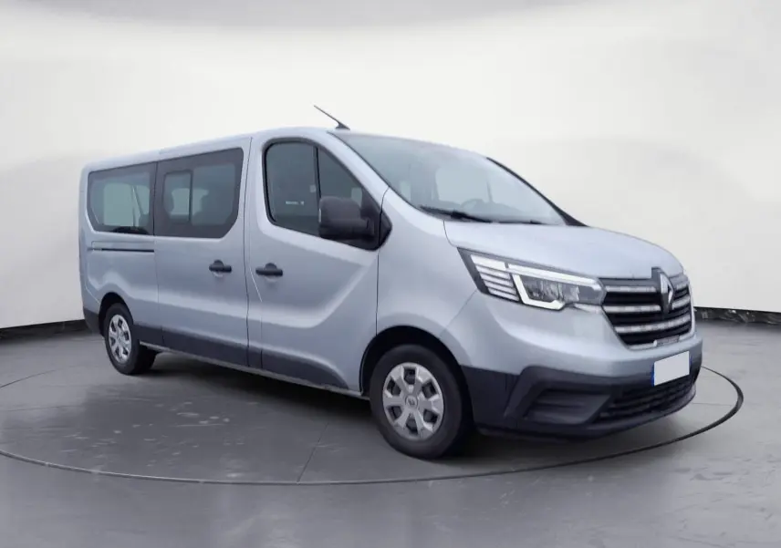 Renault Trafic Combi gris clair métal vu de trois quarts avant droit, mettant en valeur ses grandes fenêtres latérales.
