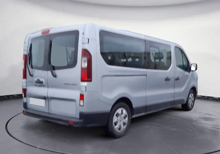 Renault Trafic Combi gris clair métal vu en 3/4 arrière droit, avec grandes vitres latérales et portes arrière vitrées.
