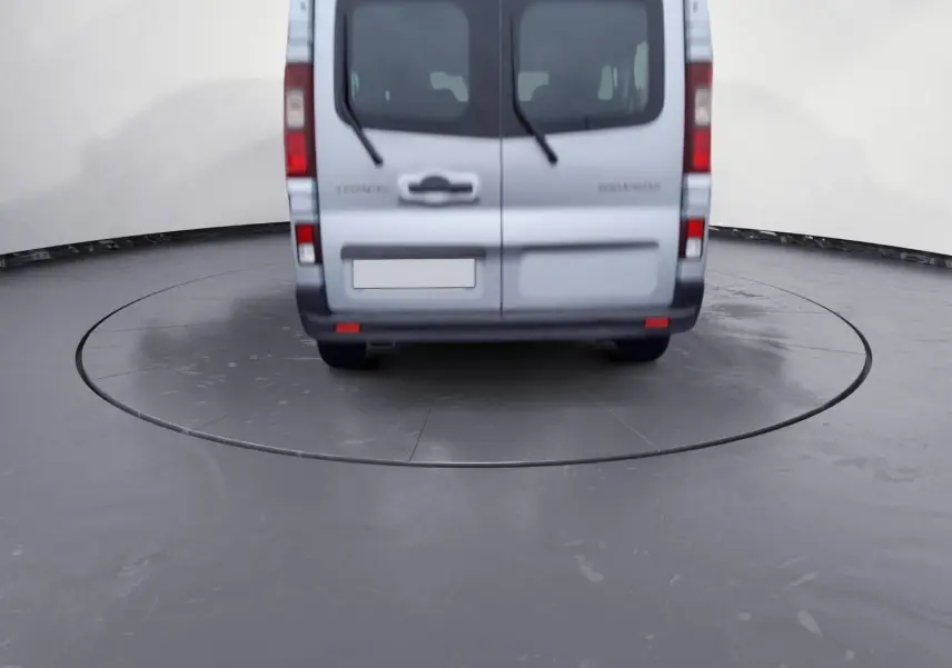 Vue arrière d'un Renault Trafic Combi gris clair métal 2023, avec portes battantes et essuie-glaces arrière visibles.