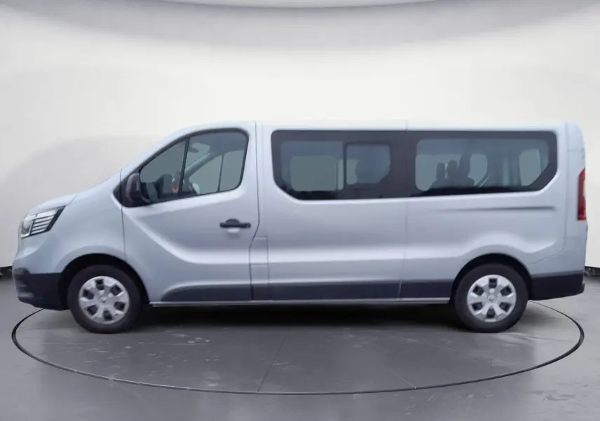Profil côté gauche d'un Renault Trafic Combi gris clair métal 2023, grand utilitaire avec fenêtres latérales.