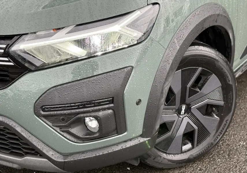 Gros plan sur l'avant droit du Dacia Jogger Kaki Lichen, mettant en valeur le phare LED et la roue avec enjoliveur noir.
