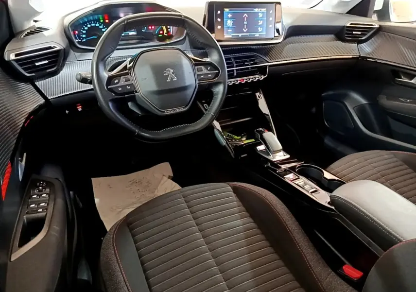Vue intérieure avant de la Peugeot 208 Electrique Active Business 2021, tableau de bord avec écran tactile et volant cuir noir.