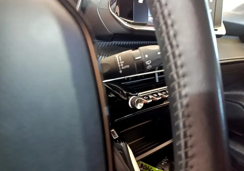 Gros plan intérieur sur le volant cuir et la console centrale noire de la Peugeot 208 électrique Active Business 2021.