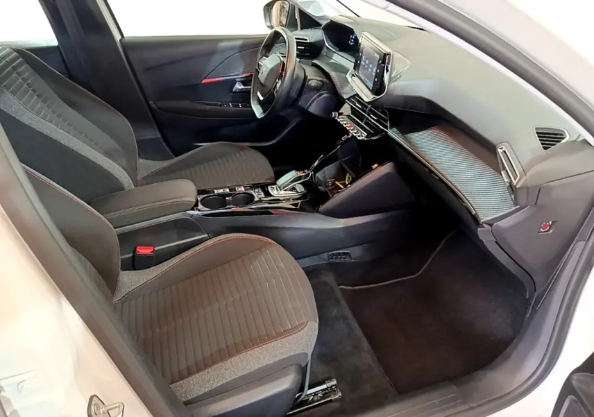Vue intérieure côté conducteur de la Peugeot 208 Electrique Active Business blanche, avec tableau de bord moderne et écran tactile.