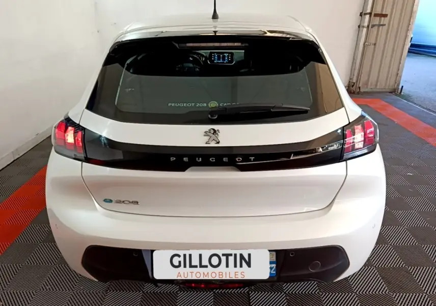 Vue arrière d'une Peugeot 208 électrique Active Business blanche, avec feux LED et bande noire distinctive sur le hayon.