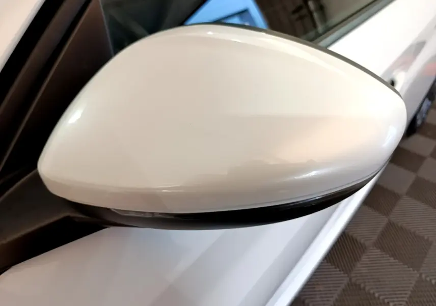 Rétroviseur blanc côté conducteur d'une Peugeot 208 électrique Active Business 2021, vue rapprochée en angle.