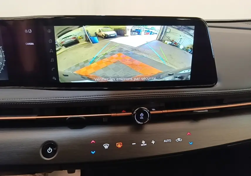 Écran tactile central affichant la caméra de recul dans l’habitacle du Nissan Ariya noir, vue intérieure du tableau de bord.