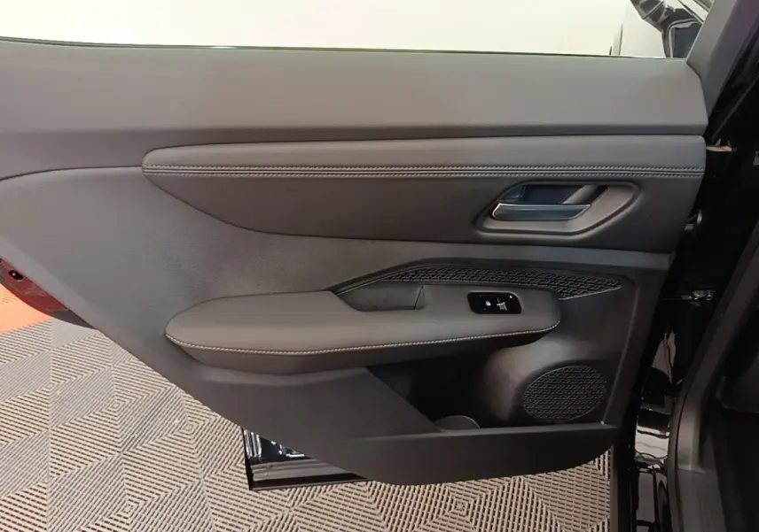 Vue intérieure de la porte arrière droite noire du Nissan Ariya 63kWh avec garniture cuir et commandes électriques.