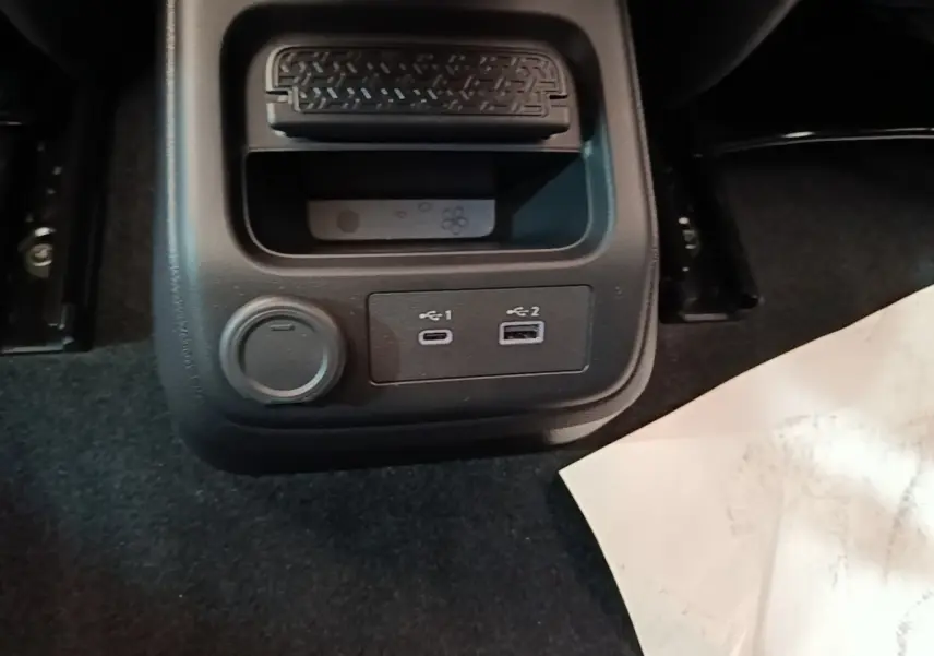 Gros plan sur la console centrale arrière noire du Nissan Ariya avec prises USB-C et USB-A, et prise 12V.