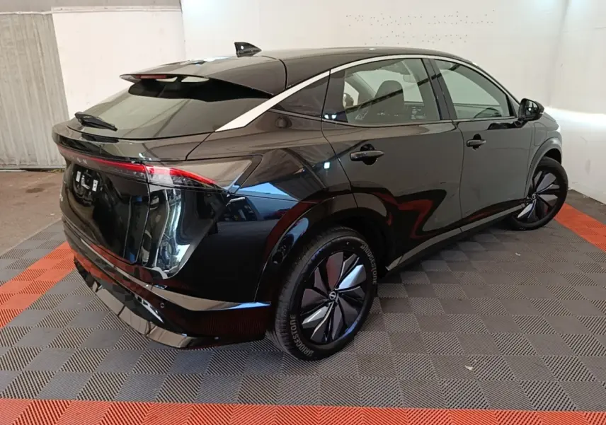 Vue 3/4 arrière droite du Nissan Ariya noir 63kWh 218ch Engage avec feux arrière LED et jantes spécifiques.
