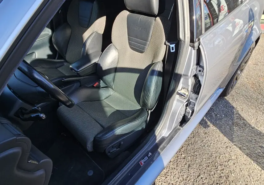 Vue intérieure côté conducteur d'une Audi RS4 Avant grise de 2001, siège sport Recaro avec logo RS4 brodé.